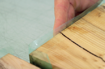 crear una barrera que ayude a contener la resina una vez que sea vertida sobre la superficie de la madera.